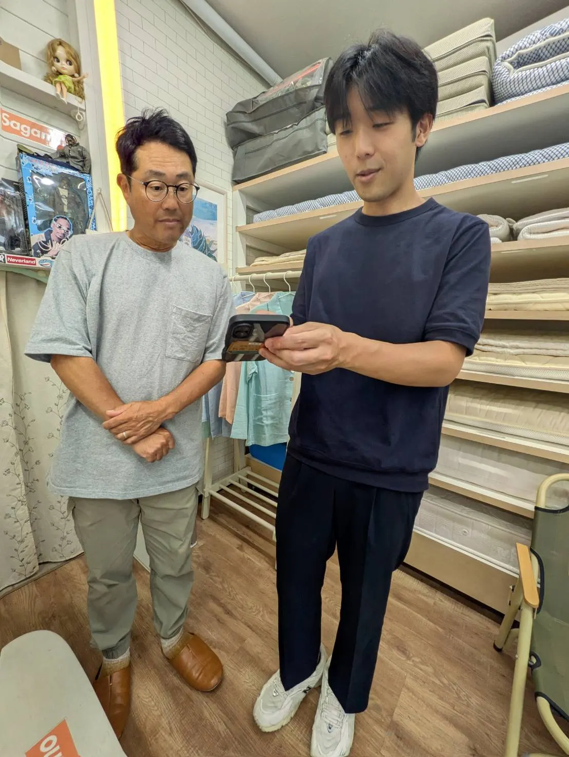 街の布団屋さん さがみ野様とS-passo担当者が店内でスマートフォンの画面を確認している様子